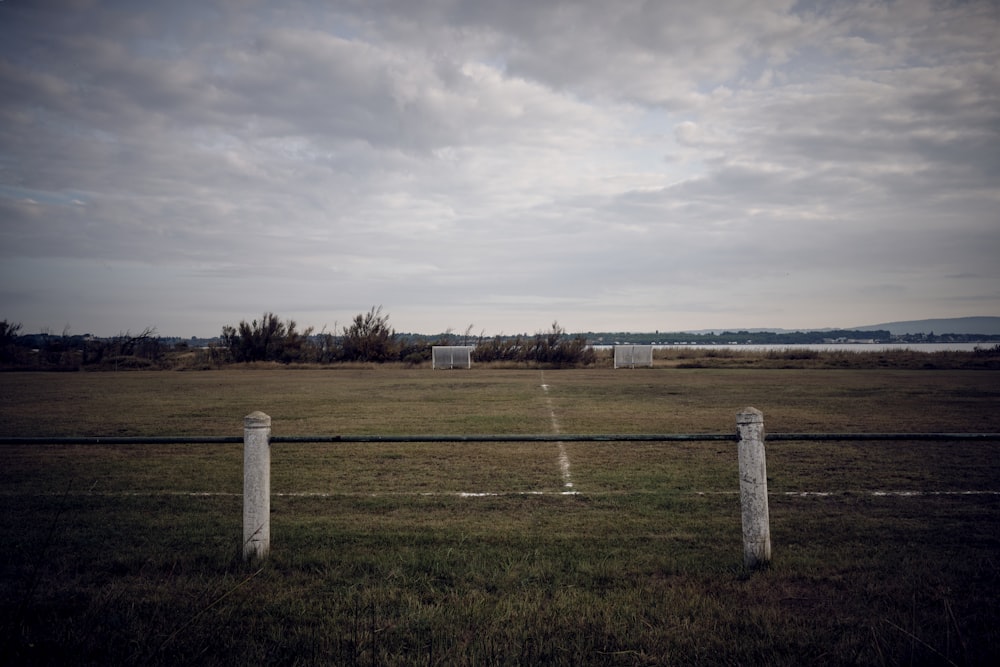 a field with a fence and some grass