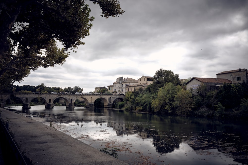 a river with a bridge and buildings in the background