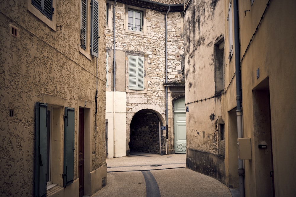 a narrow alley way with a stone building in the background