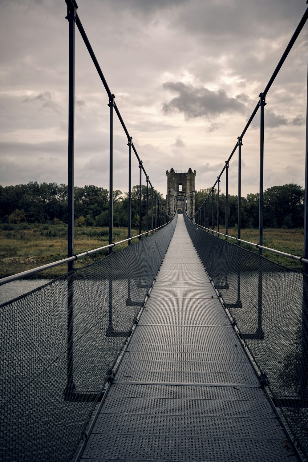 a long bridge with a clock tower in the background