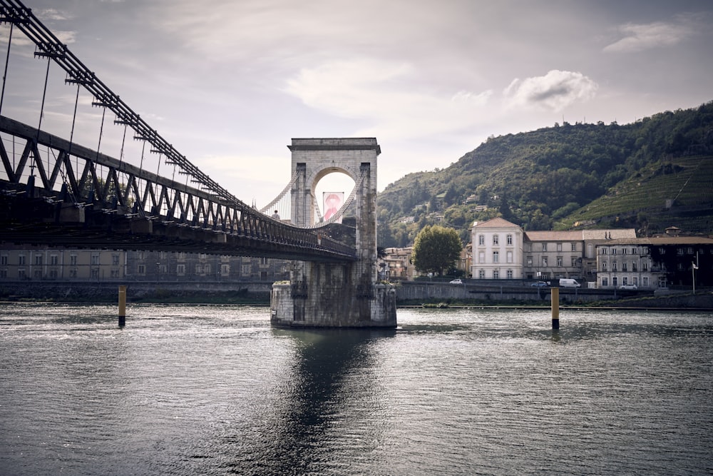 a bridge over a body of water with buildings in the background