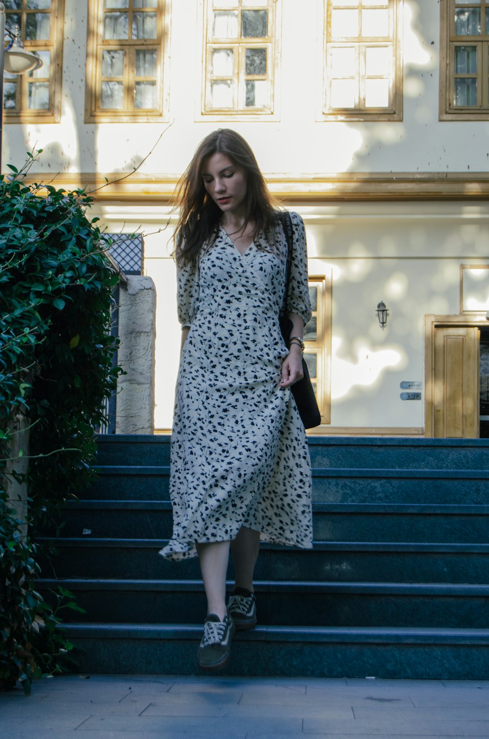 a woman in a dress walking up some steps