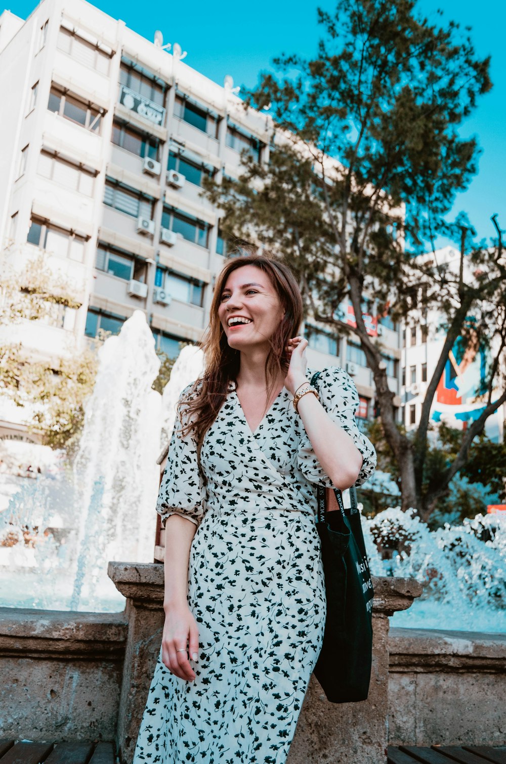 a woman standing in front of a fountain