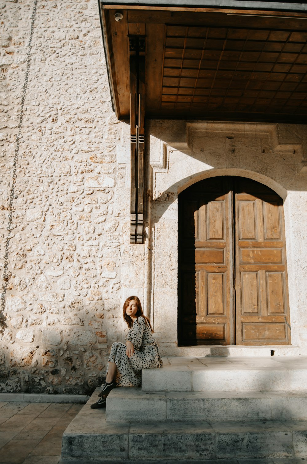 a woman sitting on steps in front of a building