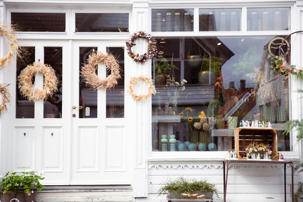 a store front with wreaths hanging on the windows