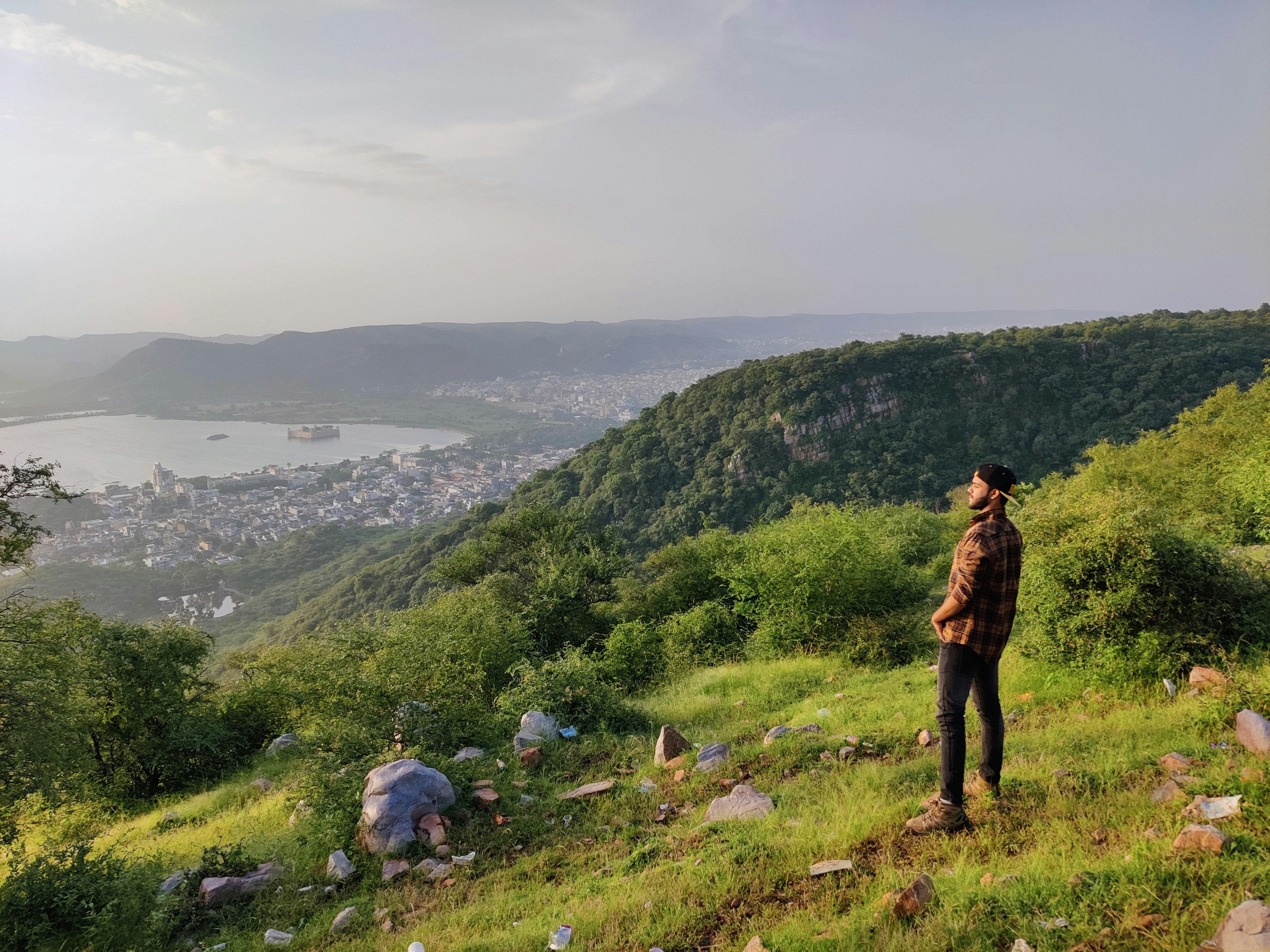 a man standing on top of a lush green hillside