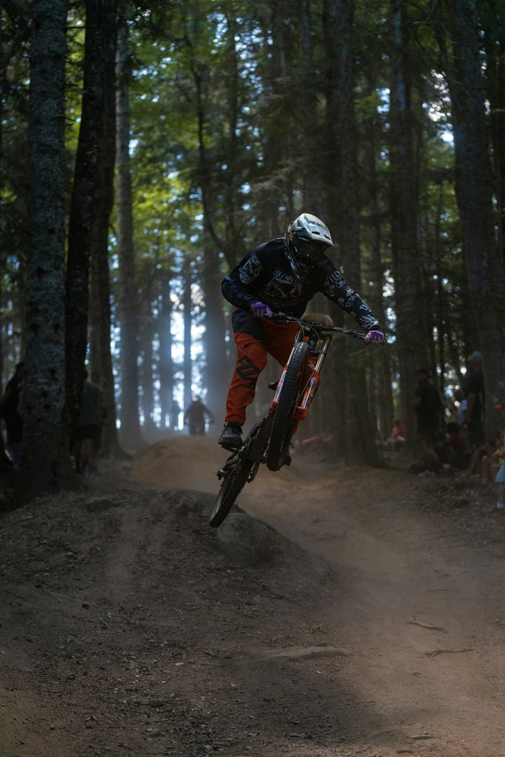 a man riding a bike down a dirt road