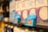 Shelves of milk cartons with blue price tags displaying a price of 1.19 in a grocery store. The focus is on the price tag with surrounding cartons slightly blurred.