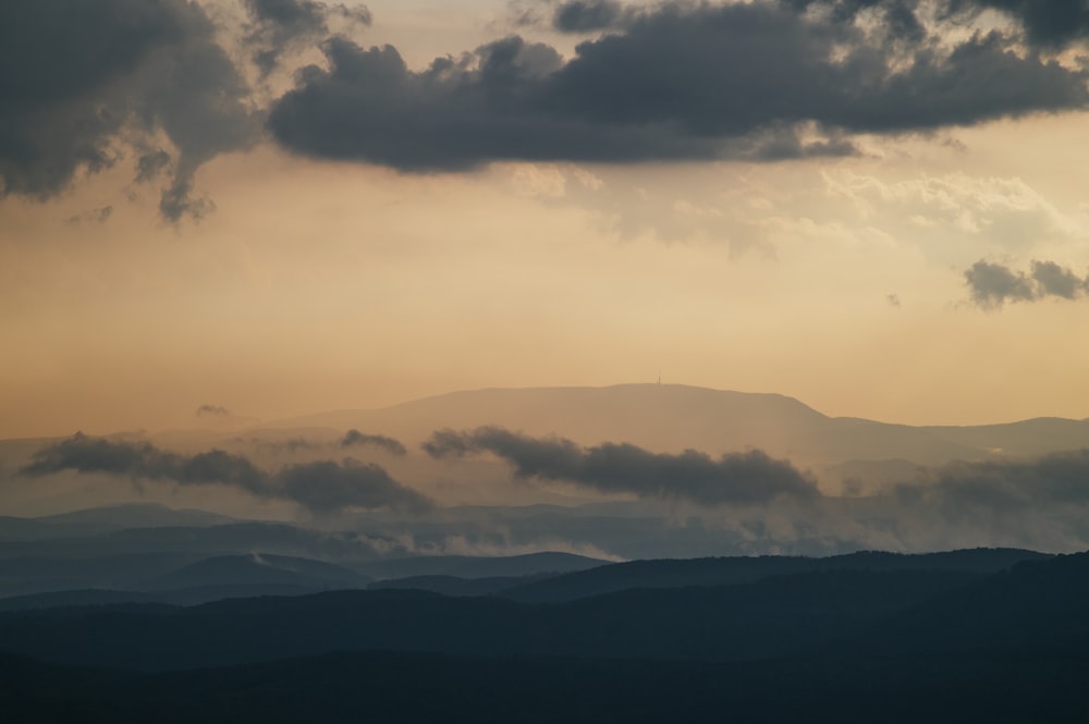 a view of a mountain range covered in clouds