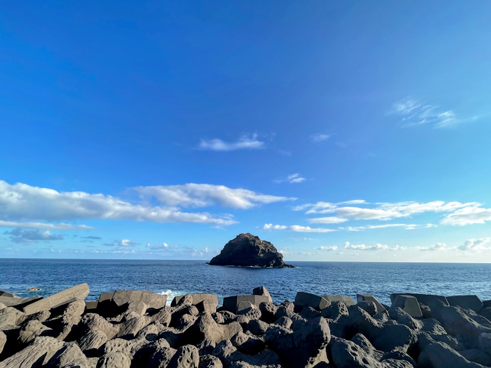 a rocky beach with a small island in the distance