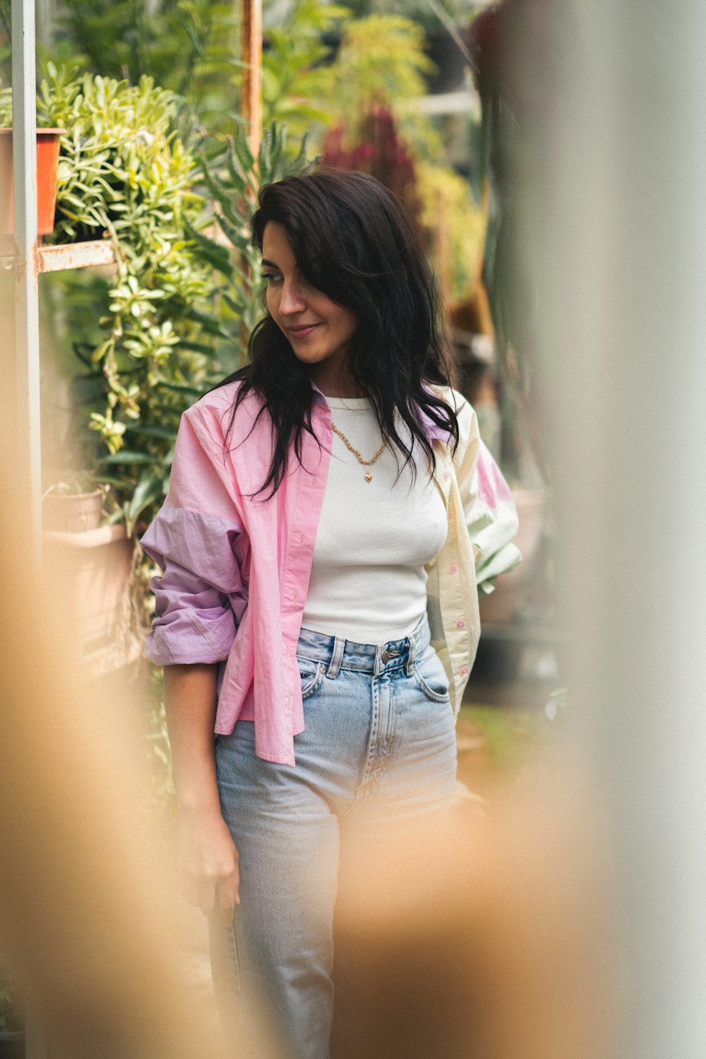 a woman in a pink jacket and jeans