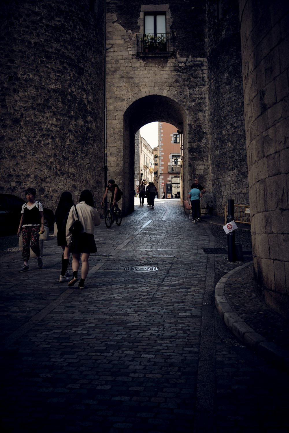 um grupo de pessoas caminhando por uma rua de tijolos