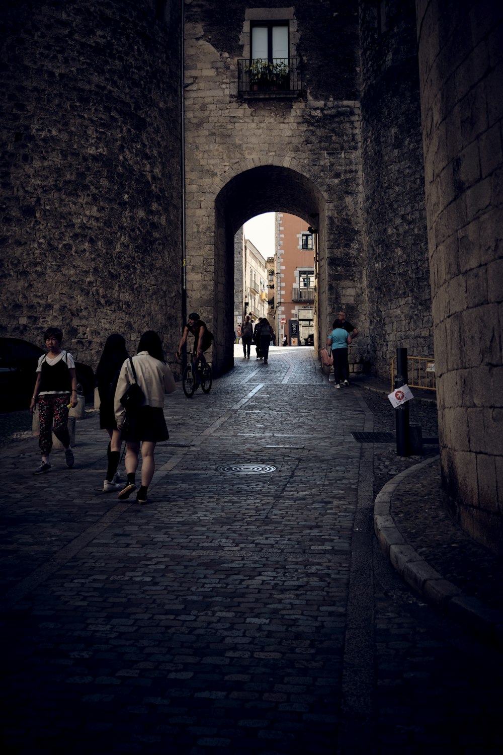 a group of people walking down a brick street