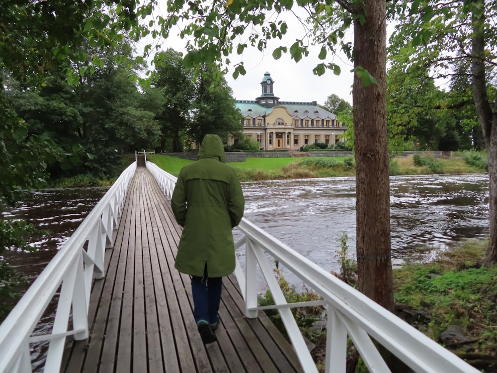 eine Person, die über eine Brücke über einen Fluss geht