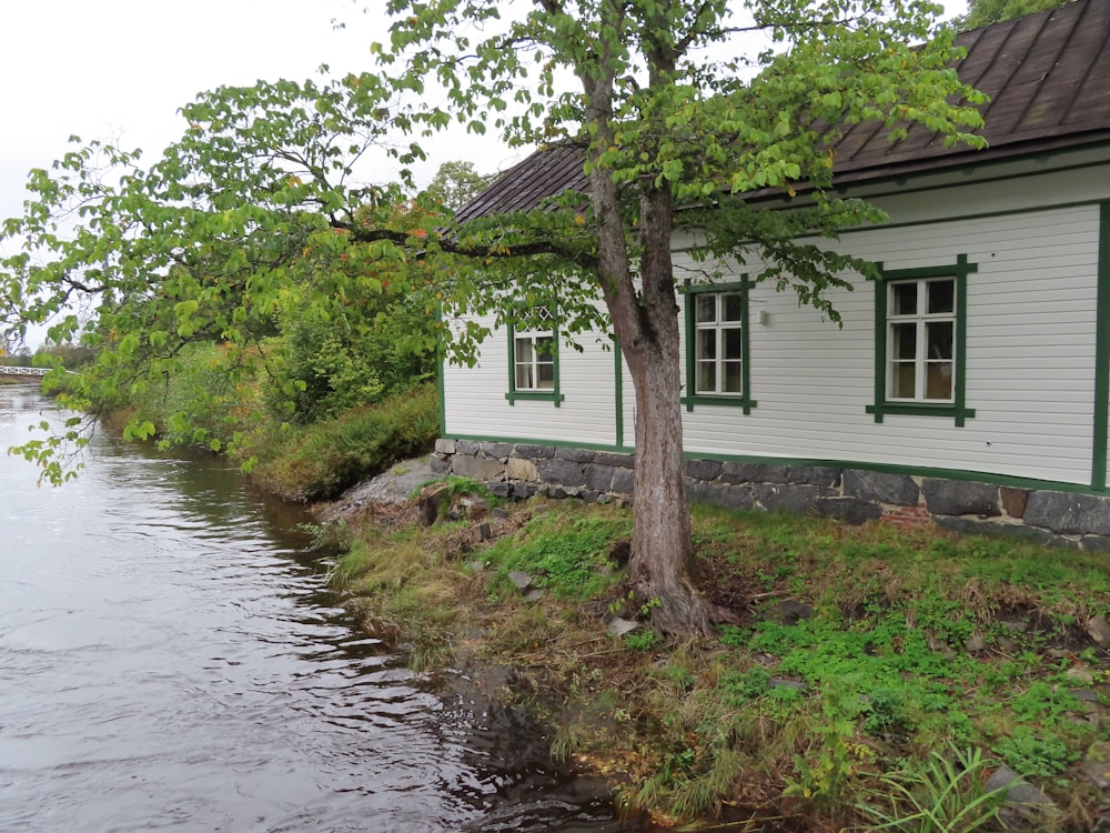 Ein kleines weißes Haus, das an einem Fluss sitzt