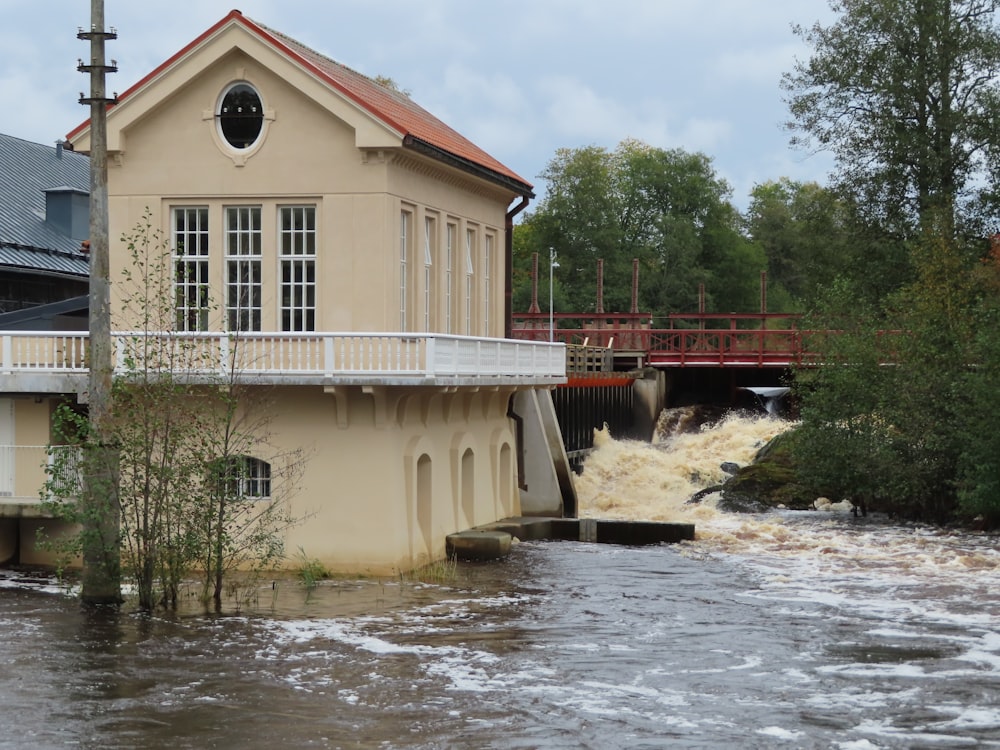 ein Haus an einer überfluteten Straße mit einer Brücke im Hintergrund