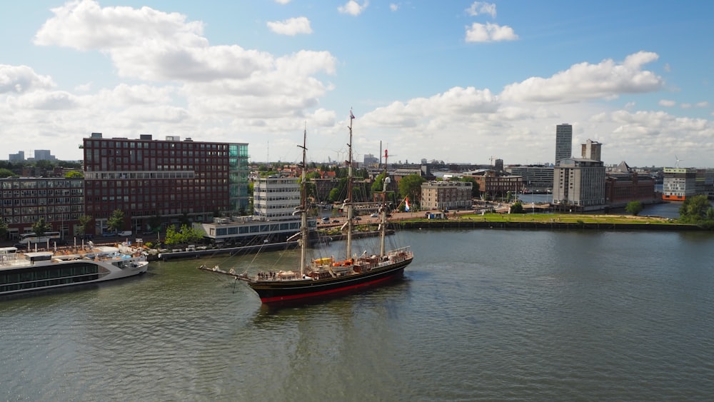 a large boat floating on top of a river next to tall buildings