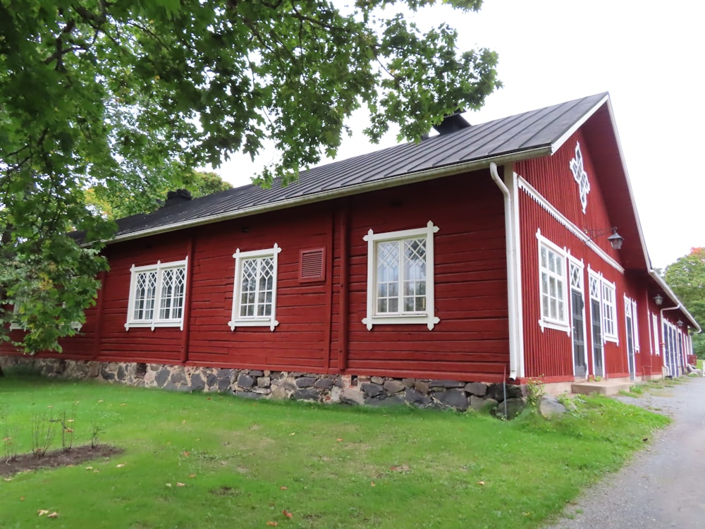 a red house with white windows and a black roof