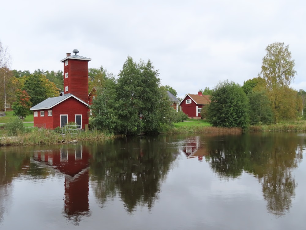 a red house sitting on top of a lush green field