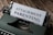 A vintage typewriter with a sheet of paper partially inserted, displaying the words 'ATTACHMENT PARENTING'. The typewriter is placed on a wooden surface, adding a rustic and nostalgic touch to the scene.