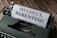 A close-up of a vintage typewriter with a sheet of paper inserted, displaying the text 'MINDFUL PARENTING' in bold letters. The typewriter is placed on a wooden surface.