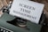 A vintage typewriter with a piece of paper inserted that reads 'Screen Time Management' in bold fonts. The machine sits on a wooden surface, suggesting an old or rustic setting.