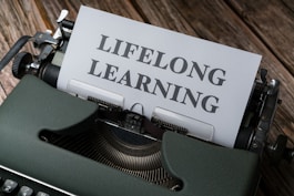 a close up of a typewriter with a paper that says lifelong learning