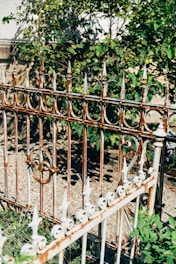 Freshly installed metal fence surrounding a garden area.