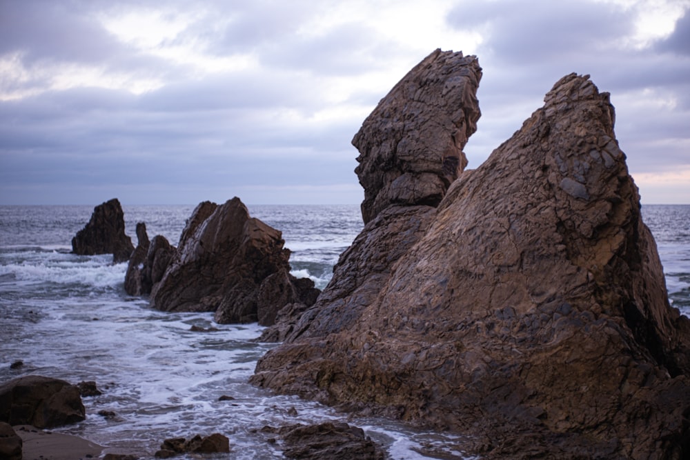 a couple of large rocks sitting on top of a beach