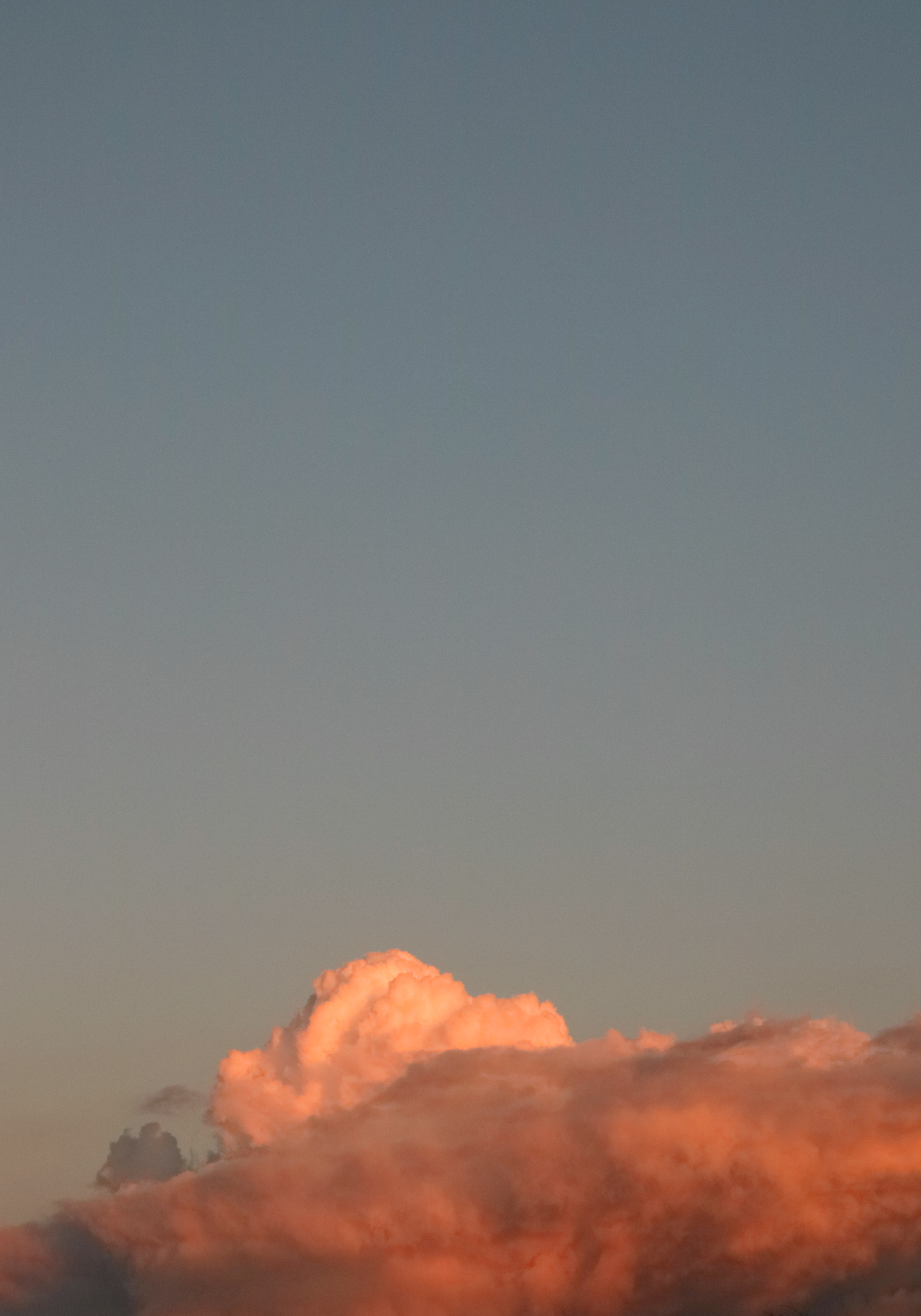 a plane flying in the sky at sunset