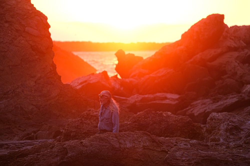 a person sitting on a rock near the ocean