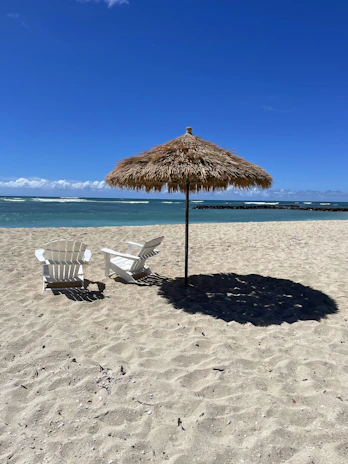 Sunlit beach chairs and umbrellas set up on the golden sands of Oak Island, ready for a relaxing day.