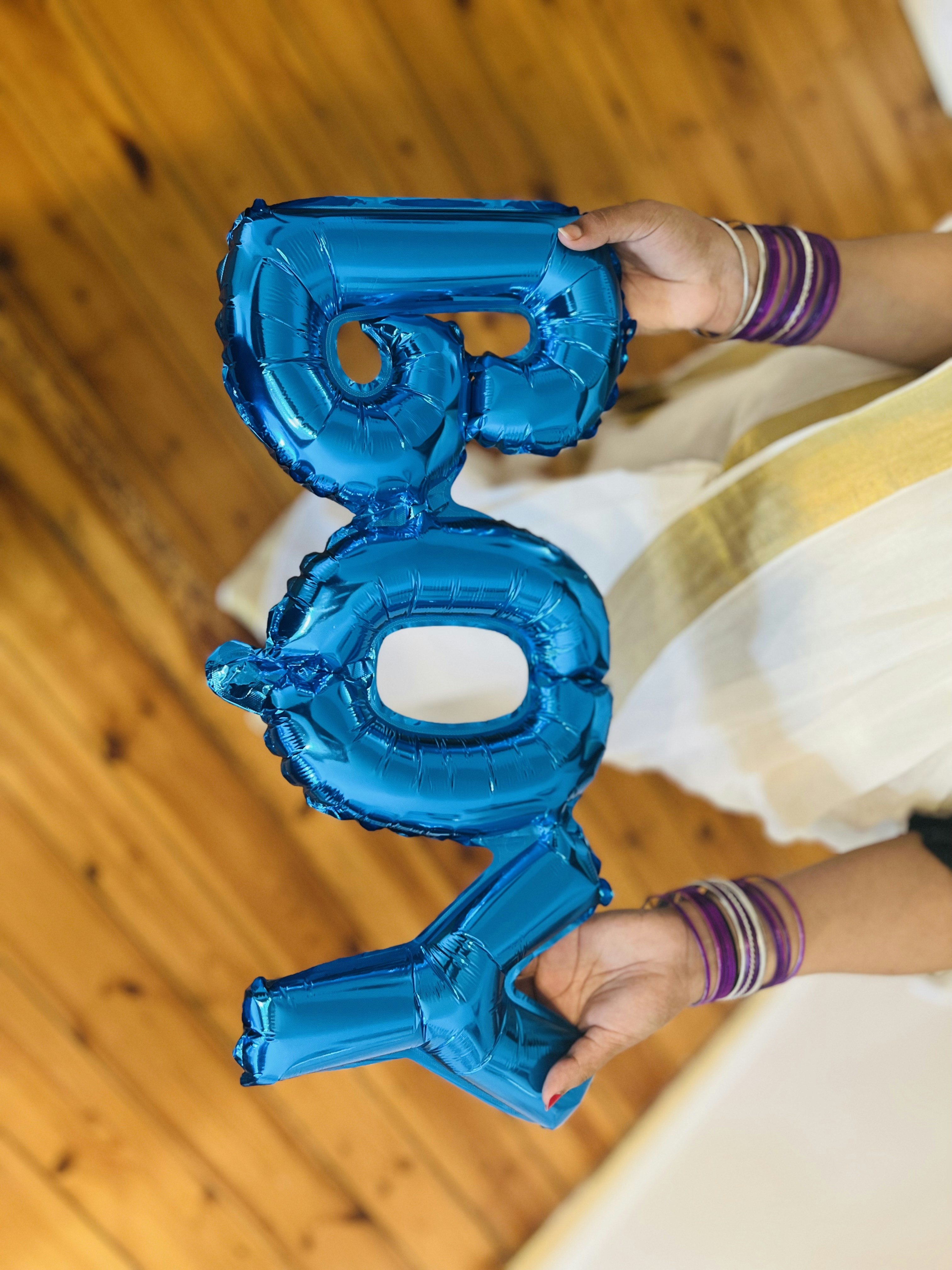 a person holding two blue balloons in their hands