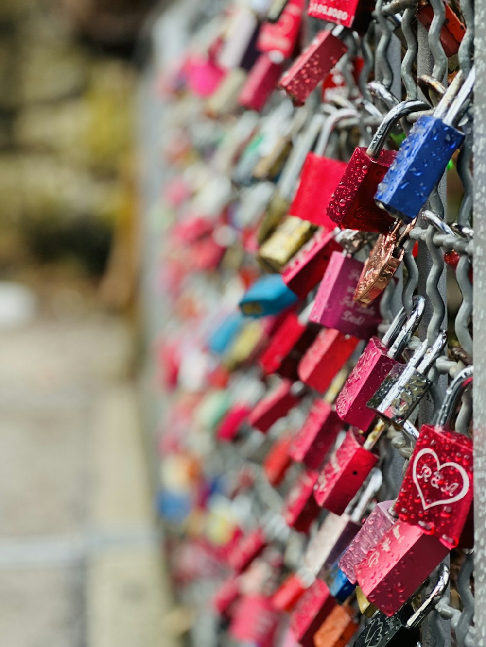 a bunch of padlocks attached to a fence