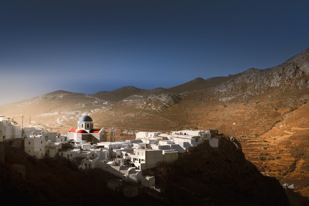 a small village on a mountain side with a church on top of it