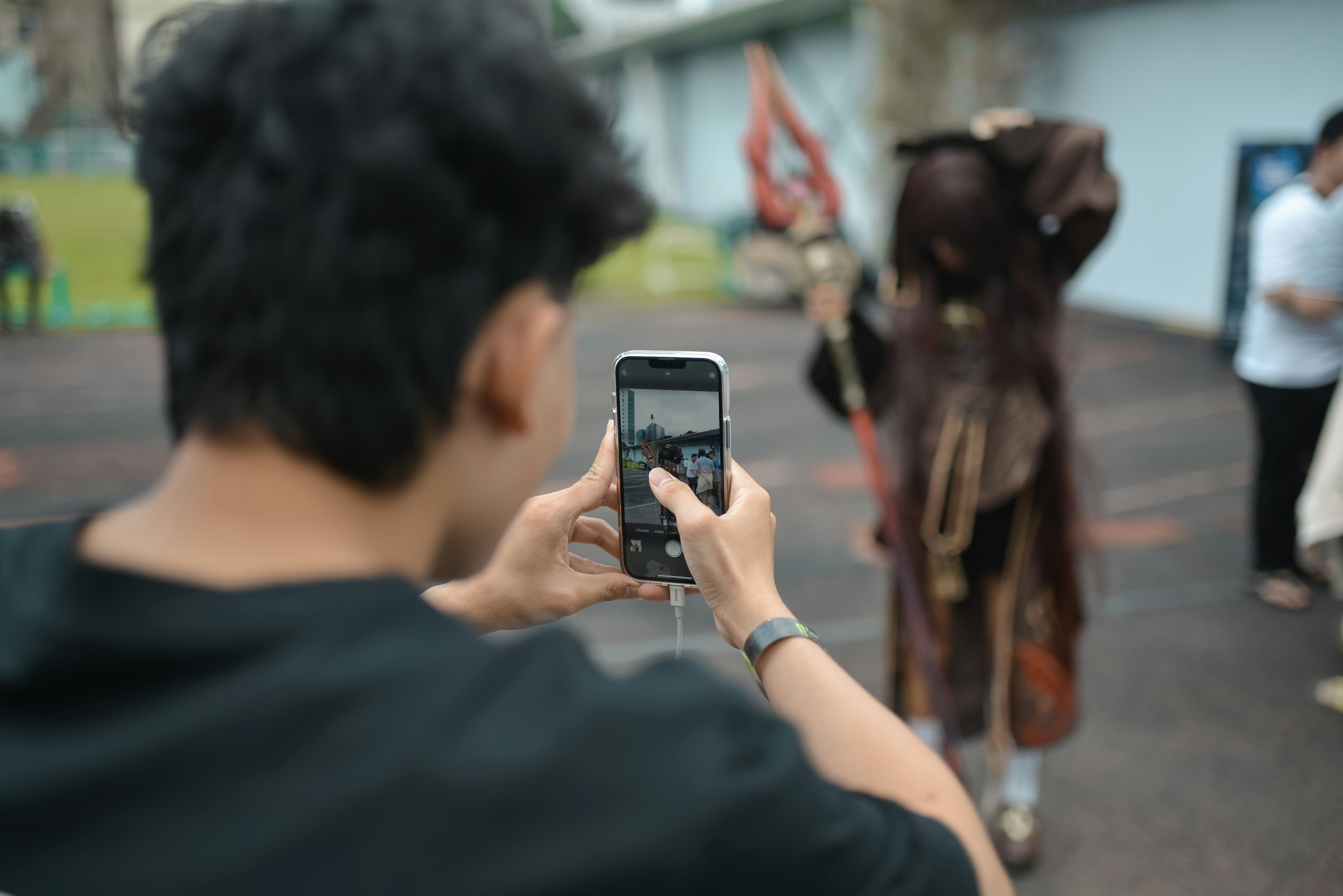 a man taking a picture of a horse with a cell phone