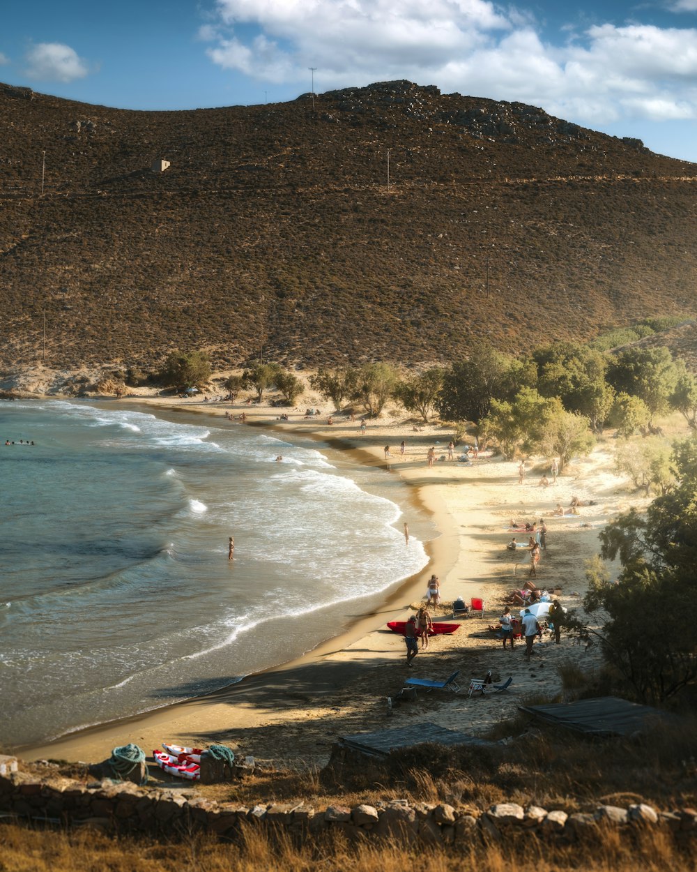 a group of people standing on top of a sandy beach