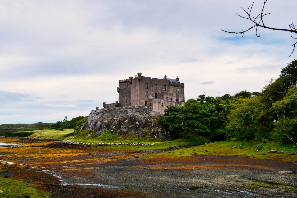 a castle sitting on top of a lush green hillside