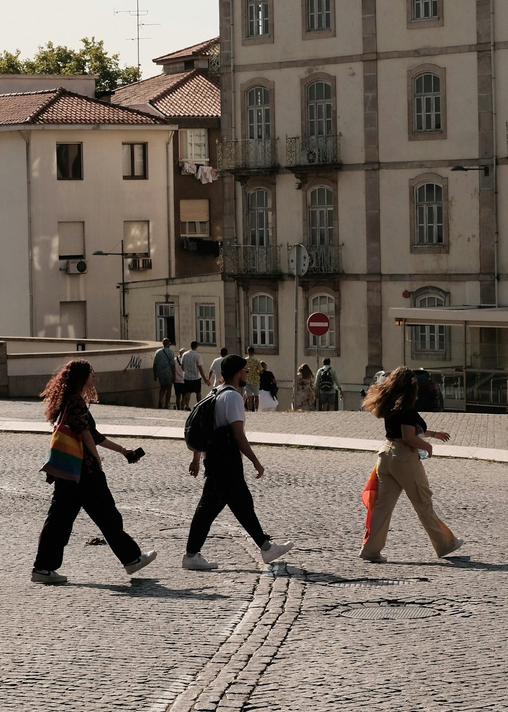 a group of people walking across a street