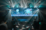 Attendees networking at a technology conference with digital displays in the background.