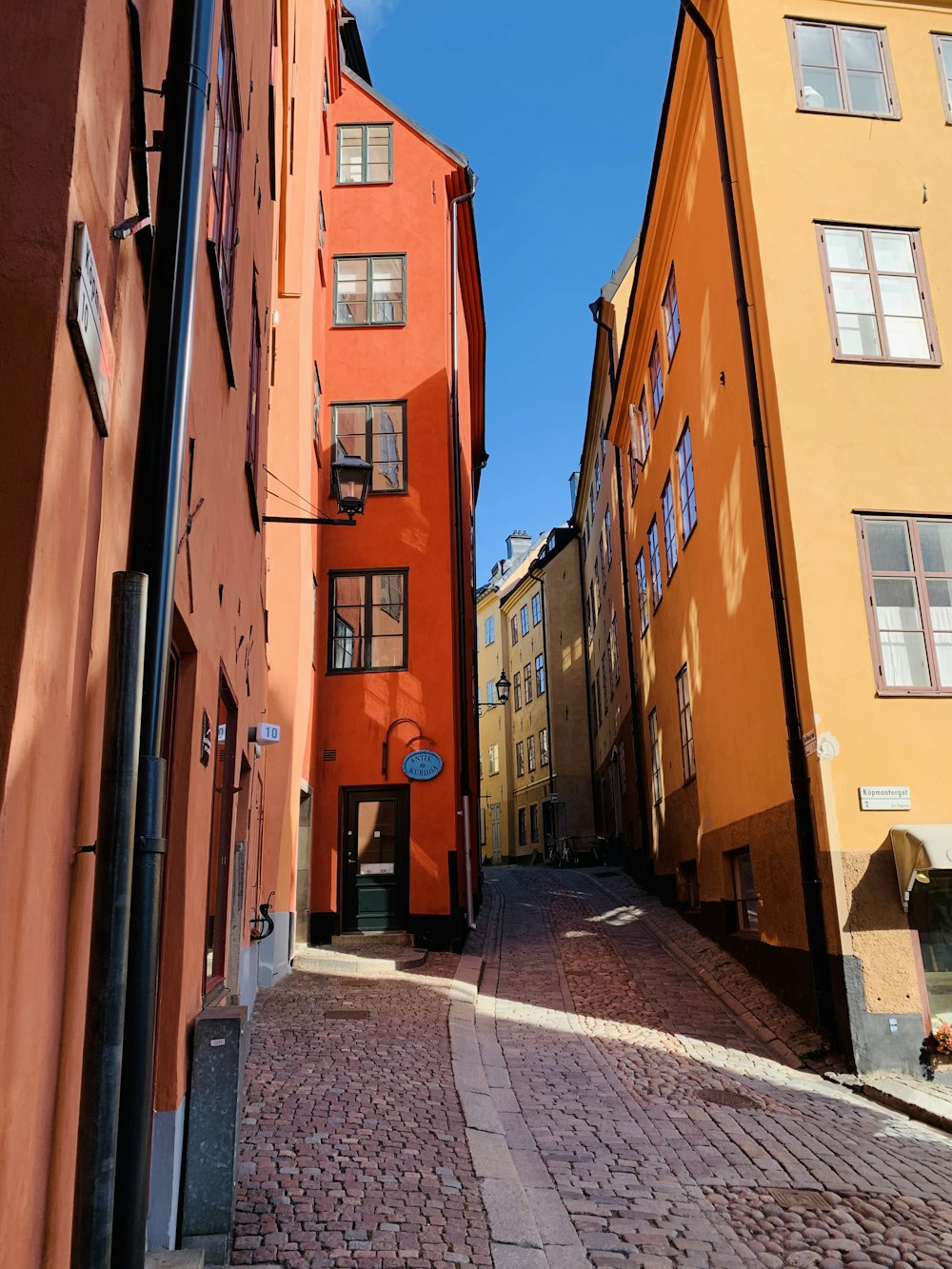 a narrow cobblestone street lined with tall buildings