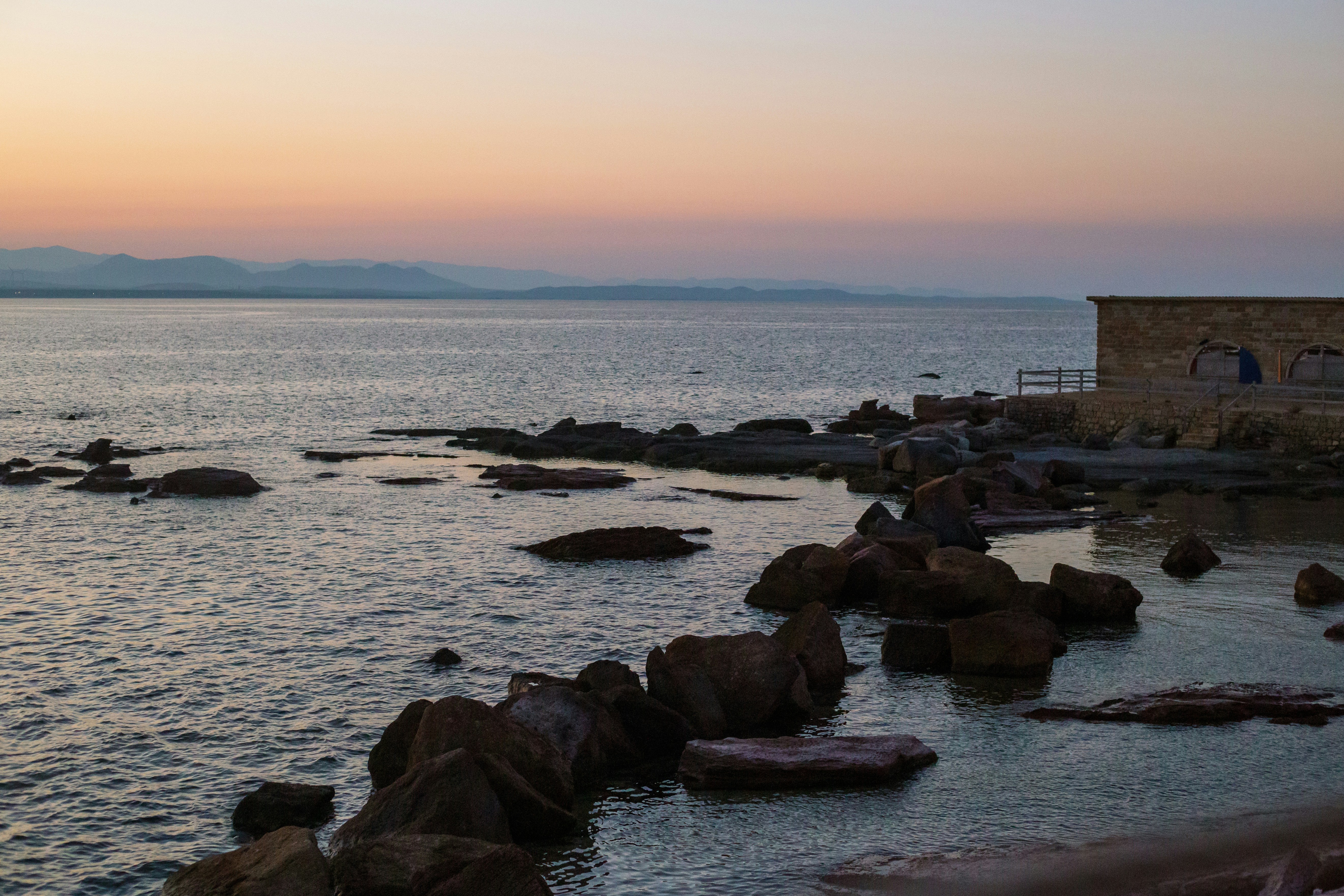 a body of water with rocks in the foreground