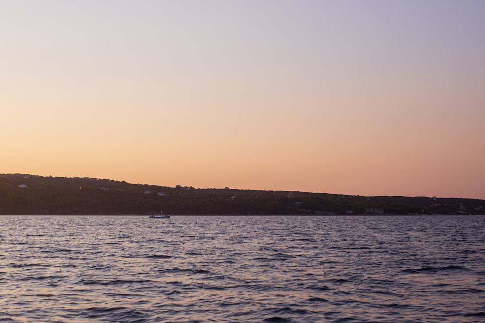 a body of water with a hill in the background