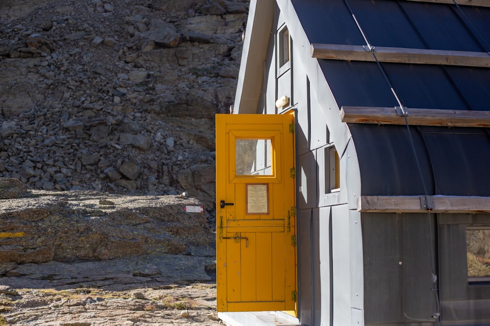 a yellow door to a building with a mountain in the background