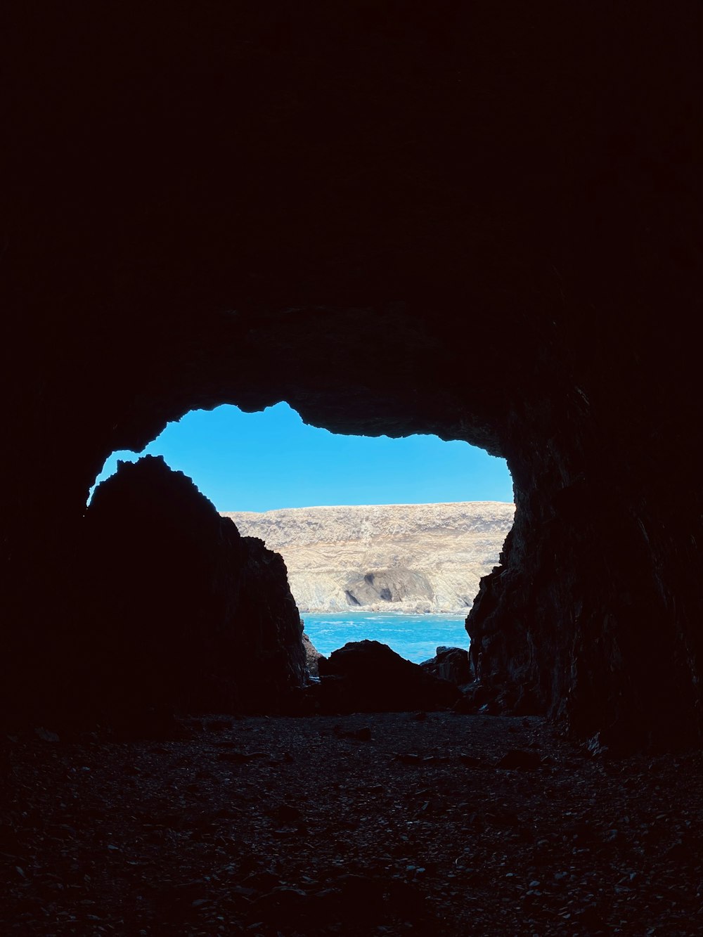 a dark cave with a blue sky in the background
