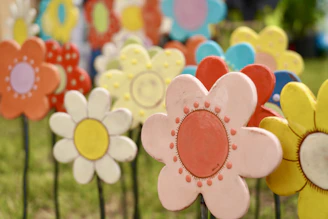 Handcrafted garden decorations displayed among blooming flowers in a sunny garden