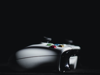 Close-up of a neon-lit vintage game controller on a dark background.