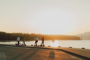 A group of diverse riders enjoying a sunny day on scooters.