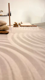 A serene modern Zen garden with smooth stones and minimalist greenery under soft natural light.