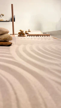 A serene modern Zen garden with smooth stones and minimalist greenery under soft natural light.